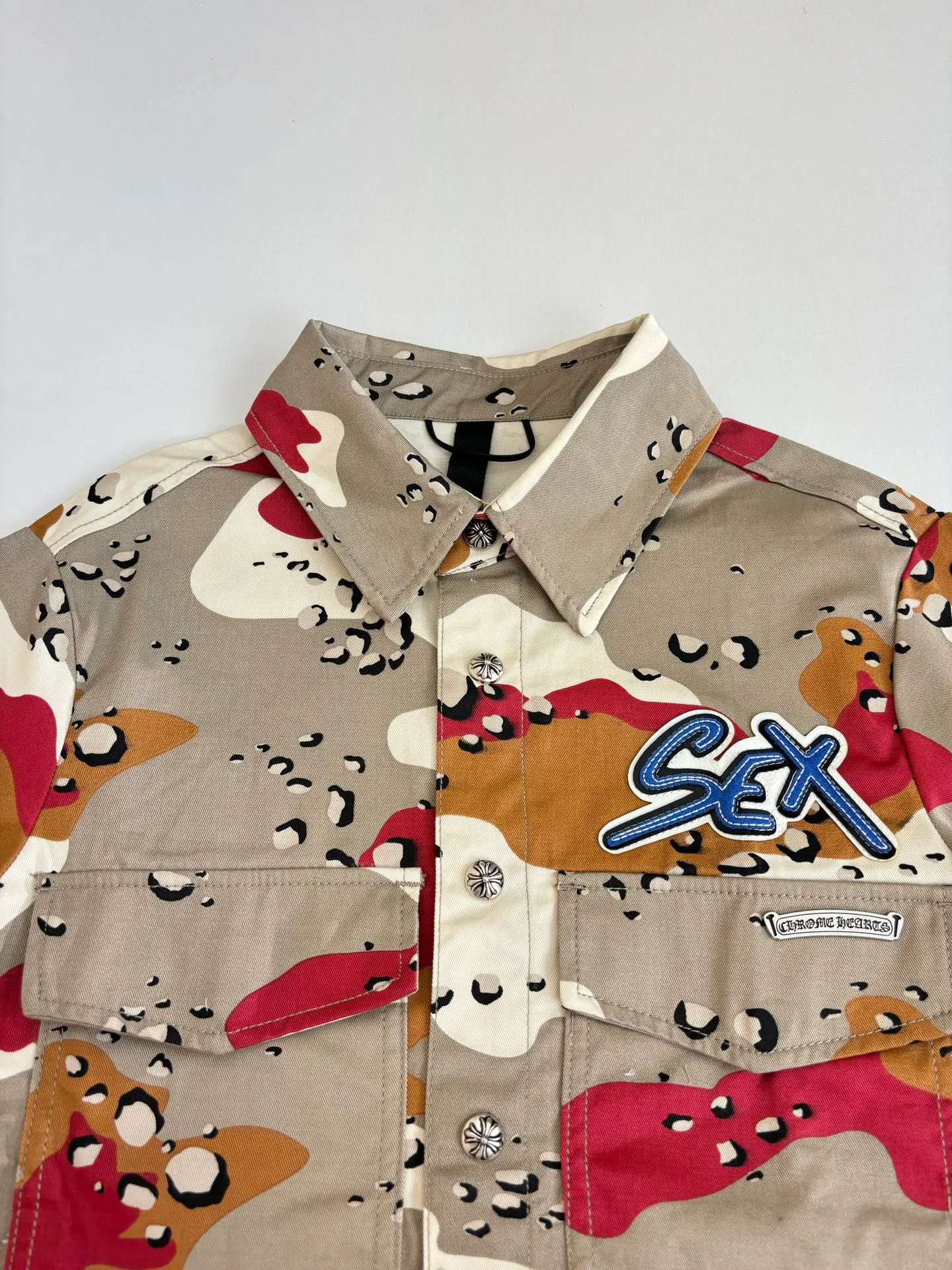 P560 Chrome Heart*/Chrome Heart CH camouflage short-sleeved denim shirt was purchased and developed by a Los Angeles agent for US$3,200. This model is made of customized military canvas fabric, restored 1:1 according to the original model, and printed with camouflage patterns. The customization period for the chest sex pattern stamp is 20 days, the minimum order is 1800 pieces, and the color plate is matched. The hardware buckles are all made of electroplated 925 silver material, the weight is perfectly restored, and they are aged and oxidized to black.  Size：S/M/L